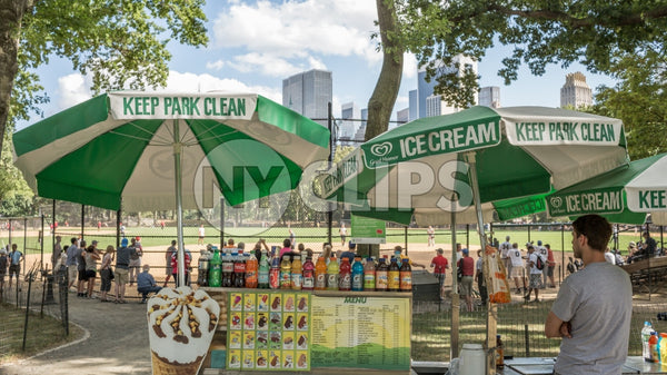 Central Park on summer day - ice cream vendor umbrella - baseball field with fence
