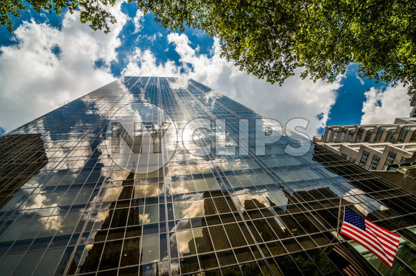glass corporate office building and American flag - upward view