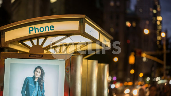 public pay phone with ad of beautiful model at night in Manhattan