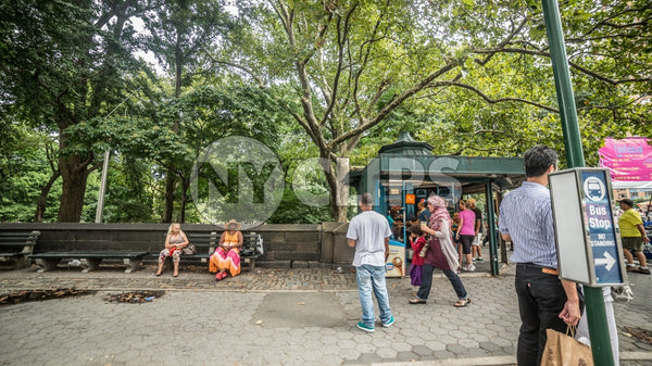 Columbus Circle with people in Midtown Manhattan on sunny summer day across the street from Central Park, trees with green leaves in NYC
