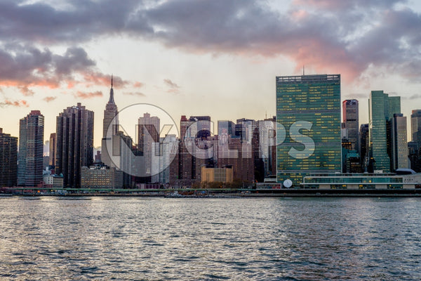 Empire State Building, United Nations, and skyscrapers in Manhattan skyline at beautiful sunset from across East River water
