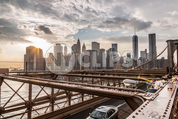 view of Manhattan skyline with skyscrapers and Freedom Tower from Brooklyn Bridge at sunset in NYC