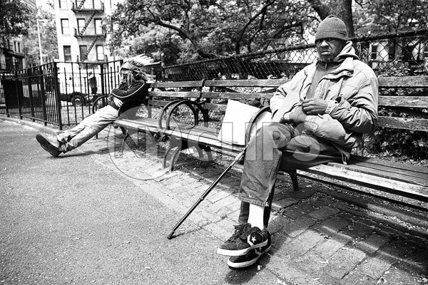 man with cane on park bench in NYC