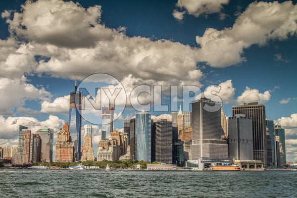 skyscrapers in Downtown Manhattan with Freedom Tower unfinished across East River on beautiful day