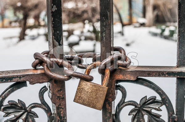locked gate in Harlem on cold winter day, snow on ground
