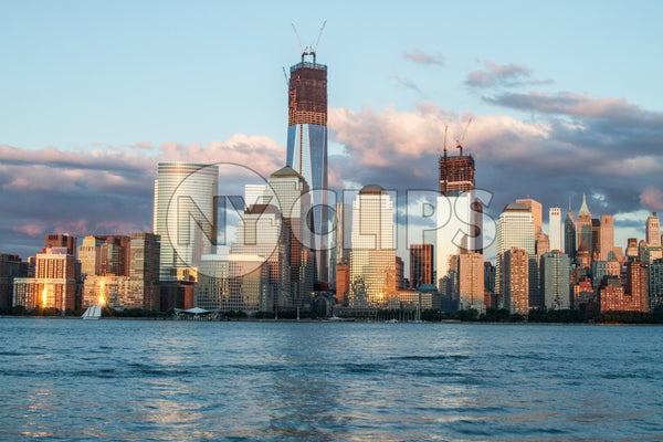 Freedom Tower under construction in Manhattan skyline in early evening from across East River water