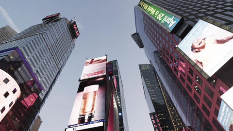 Times Square bright lights and ads from moving low angle looking up in NYC