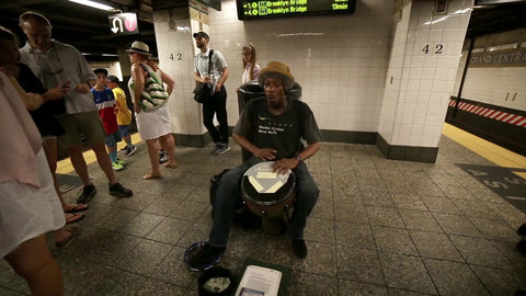 street performer musician playing conga drum in subway station interior in summer - New York City
