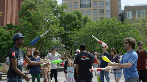 jugglers juggling bowling pins in summertime in Washington Square Park before a crowd in slow motion - 4K NYC