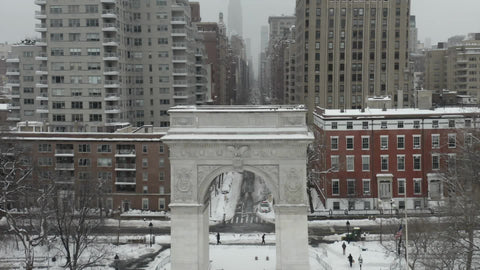 slow zoom out Washington Square Park arch white winter snow - blizzard snowing in NYC