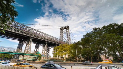 Williamsburg Bridge with cars driving during the day - 4K timelapse with blue sky and clouds in NYC
