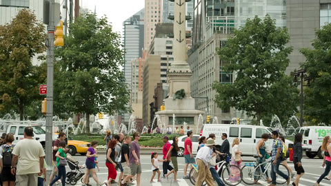 people crossing street at Columbus Circle on summer day, colorful crowded busy crosswalk in Manhattan
