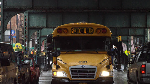 yellow school bus driving in fall rain cold rainy weather schoolbus in autumn Broadway Bed-Stuy Brooklyn New York City