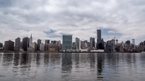 panning shot of Manhattan skyline on cloudy day from across East River water in 4K NYC