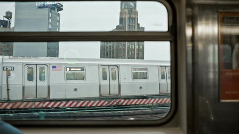 window view of other subway train on elevated track