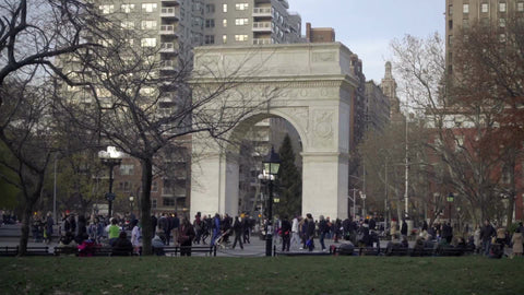 Washington Square Park arch on fall day - people walking around famous monument - far shot