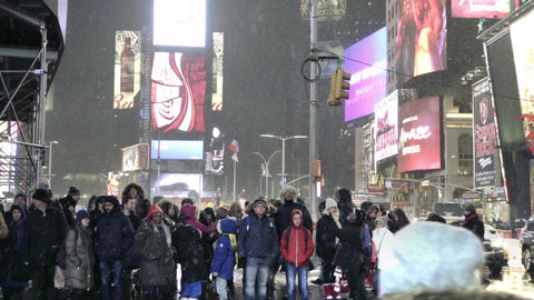 people at crosswalk waiting on busy Times Square intersection - snowing at night in slow motion