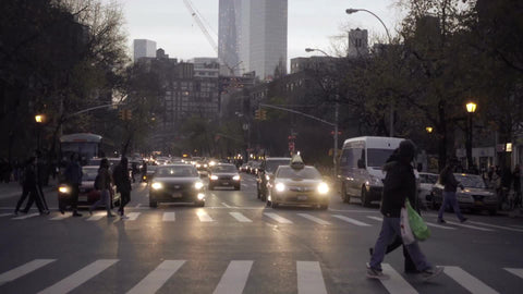 people crossing street in early evening on 6th ave with Freedom Tower in background