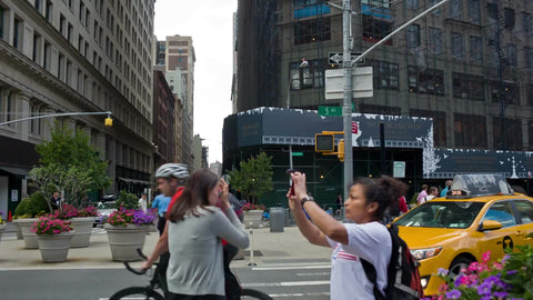 tourist taking picture - 5th Ave and Madison Square Park with Empire State Building on summer day