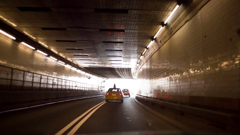 taxi driving in Lincoln tunnel - cab exiting dark into bright white daylight in NYC
