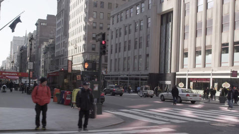 Empire State Building on 5th Ave on winter day with people walking, slow motion in NYC