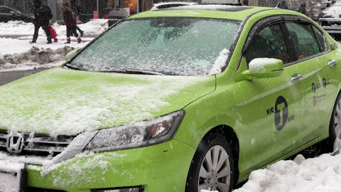 green taxi cab parked in snow storm blizzard snowing in New York City NYC