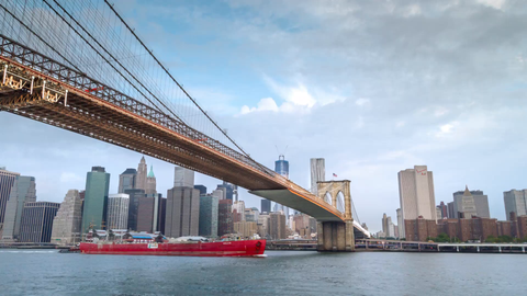 slowly pulling back from Brooklyn Bridge timelapse with Freedom Tower and Manhattan Skyline in background across East River - 4K in NYC