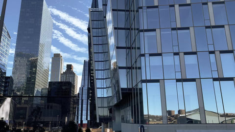driving past trees behind fence skyscrapers Hudson Yards Midtown Manhattan New York City NYC
