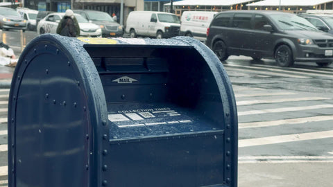 blue mail box on street snowing in winter in Manhattan NYC
