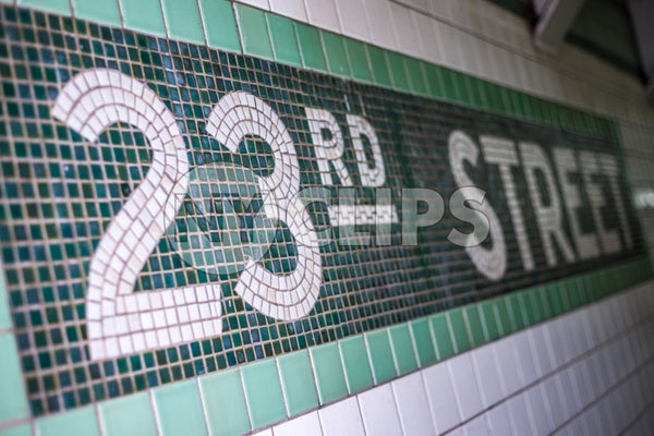 23rd st sign on subway station wall in NYC