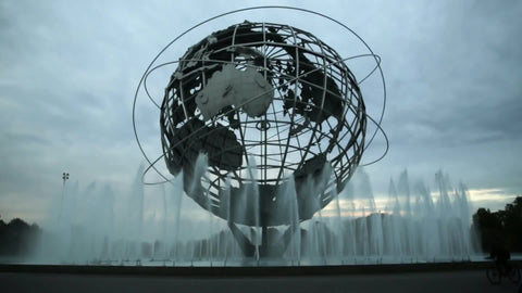 Unisphere globe sculpture with water spraying from fountains in Flushing Meadows Corona Park Queens with kids on bikes
