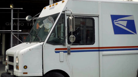 USPS truck driving in the city, turning corner in NYC