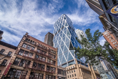 Hearst Tower - famous strange shaped skyscraper in Midtown Manhattan - odd building over blue sky