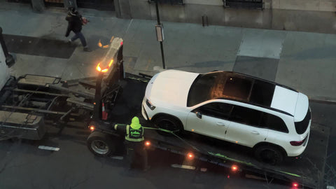 tow truck guy tightening tire on back in NYC