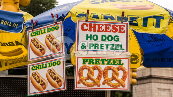 hot dog vendor umbrella - pretzels, cheese and chili dogs on sunny day