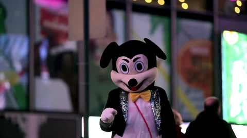 Times Square performer in Mickey Mouse costume on street at night