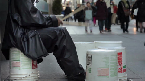 drummer playing in street on buckets on cold winter day in New York City
