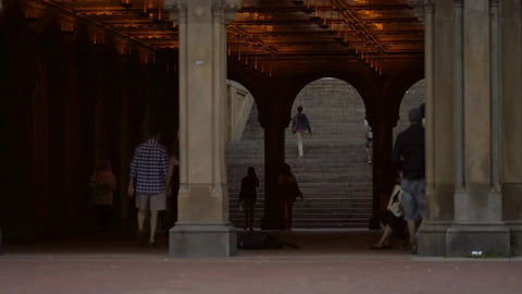people walking under Bethesda Terrace in Central Park on summer day in NYC