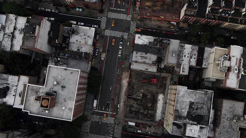 overhead three taxis driving aerial Manhattan street over buildings New York City NYC