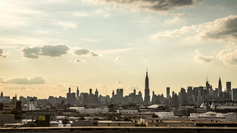 Manhattan skyline silhouette with Empire State Building view from Brooklyn in early evening sunset