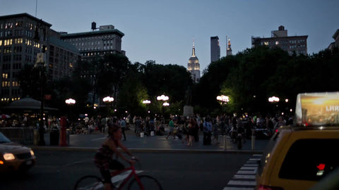 Union Square Park in early evening with Empire State Building lights in Manhattan - summer in NYC