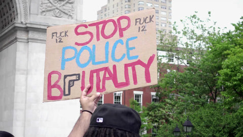 Stop Police Brutality and fuck 12 sign at BLM rally in Washington Square Park with arch in background