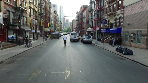 kid skating through Chinatown avoiding potholes - shot ascending above buildings in NYC