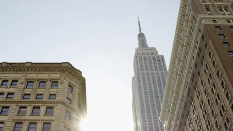 Empire State Building tilting down to Herald Square police officers with car - cop staring at camera on spring day in Manhattan NYC