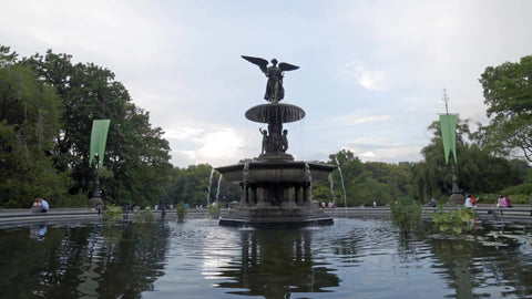 Bethesda Statue with fountain water sprinkler and ripples in pond in Central Park on summer day in NYC