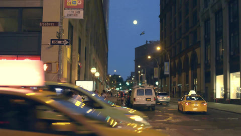 full moon over busy traffic street at night in Manhattan on Broadway in NYC