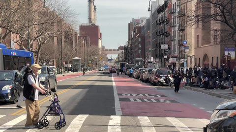 people walking on 1st avenue bus stop in Stuyvesant Town Manhattan red brick buildings housing New York City NYC