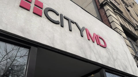 CityMD medical facility sign with people waiting in line outside in Greenwich Village New York City