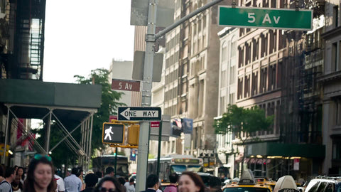 5th Avenue sign at busy intersection on 14th st in summer - people crossing street