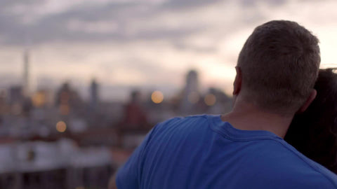 couple enjoying the view of Manhattan skyline from rooftop at sunset in NYC summer